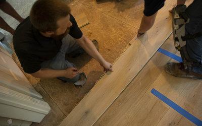 Worker installing 9" Live Sawn White Oak Flooring