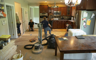 Worker installing 9" Live Sawn White Oak Flooring
